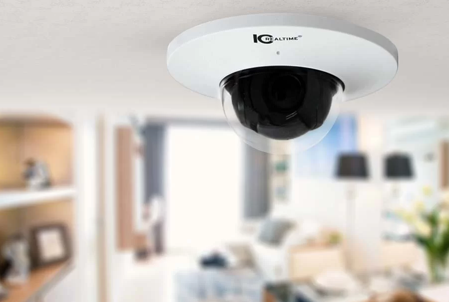 IC Realtime camera mounted on the ceiling in a home. Blurry background of a living room. 