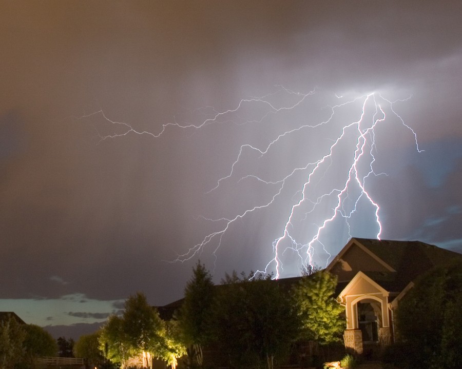 A flash of lighting above a home.